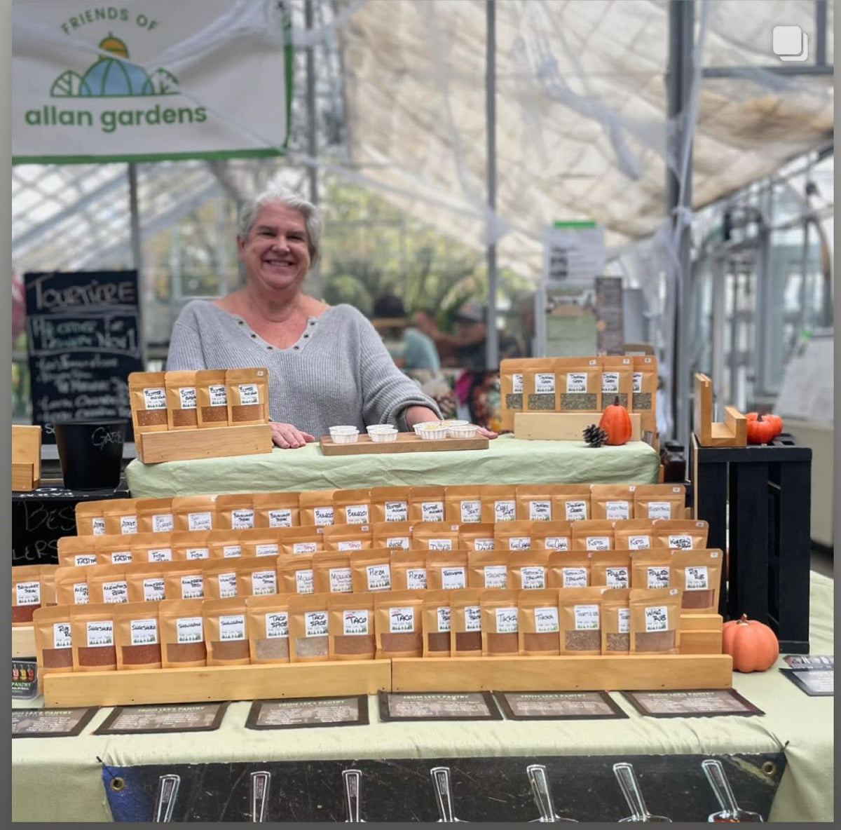Lex standing behind her spice booth at a market