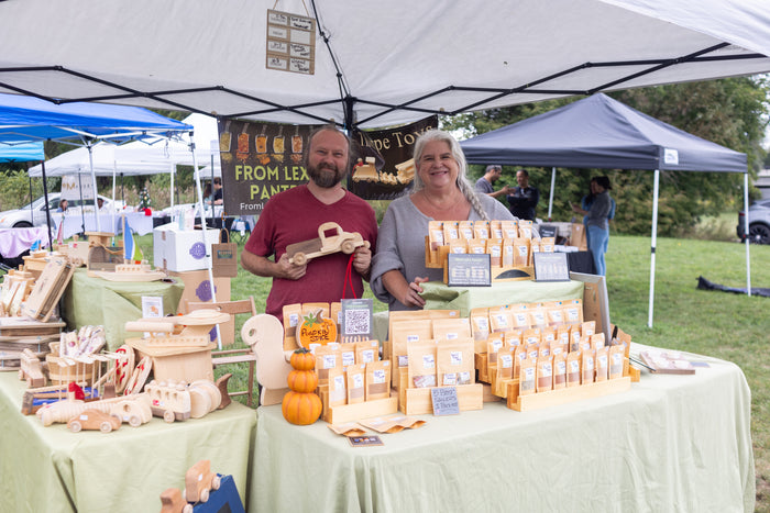 Alexa Clark from lex's pantry and Gerry Thorpe from Thorpe Toys at their market booth filled with spices and wooden toys
