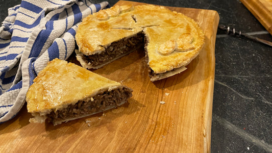 Tourtiere baked from frozen on a wooden board with a slice cut out