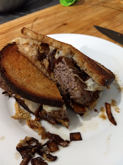 patty melt made on sourdough with fried onions  and sauce on a plate